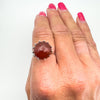 8.5ct carnelian cabochon ring worn on finger, sterling silver setting