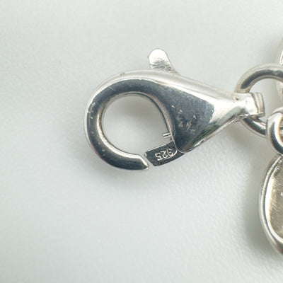 Close up of lobster clasp stamped 925 on sterling silver charm