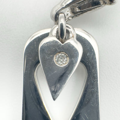 Close-up of diamond set in heart-shaped sterling silver charm