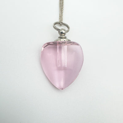 Close-up of mini pink glass heart perfume bottle pendant
