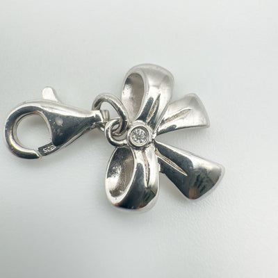 Close up of sterling silver bow charm with round cut diamond