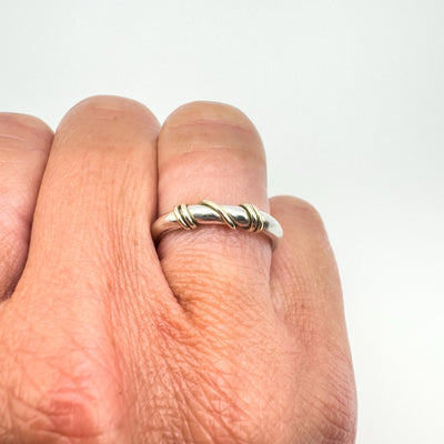 Gold and silver ring with twist detail worn on hand