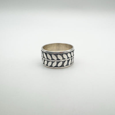 Wide sterling silver ring with engraved leaf design, front view