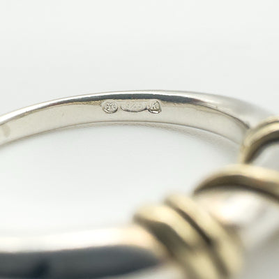 Close-up of hallmark 925 and 9ct gold stamp inside silver ring