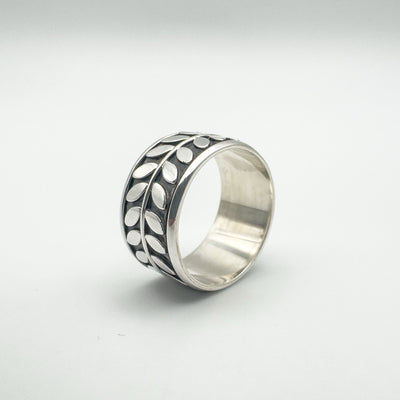 Side angle of wide sterling silver ring with moving engraved outer band