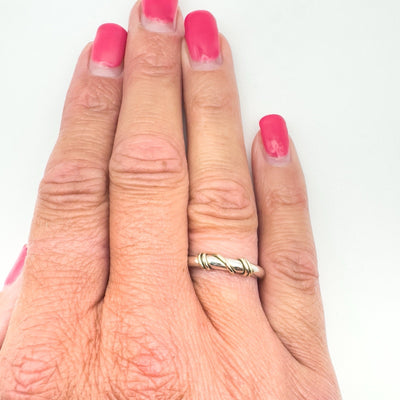 Twisted 9ct gold and sterling silver ring worn on finger