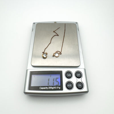 Pair of rose gold plated threader earrings on digital scale showing 1.15g total weight