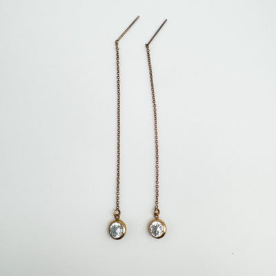  Full-length rose gold threader earrings with CZ stones laid flat