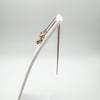 Side view of rose gold plated threader earrings on display stand