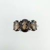 Close up of Smokey Quartz trilogy ring showing faceted oval gemstones and prong setting