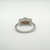 Rear view of trilogy ring with open silver setting behind three Smokey Quartz stonesEngagement