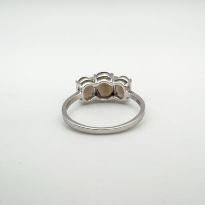 Rear view of trilogy ring with open silver setting behind three Smokey Quartz stonesEngagement