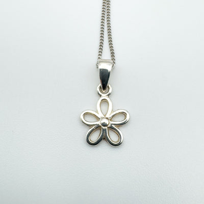 Close-up of sterling silver flower pendant with open petal design.